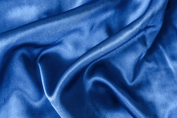 Fototapeta na wymiar Elegant smooth blue silk or satin folds closeup. Cloth texture background. Abstract wallpaper. Trendy dark skyblue backdrop for web design. Luxury twisted fabric backplate 