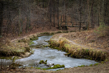 Forest river Sztoła with bridge over it, during winter time   