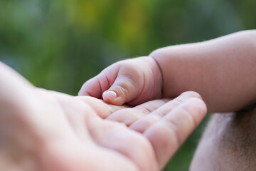 The mother is holding the hand of the child. Mother's and child hands. Family concept