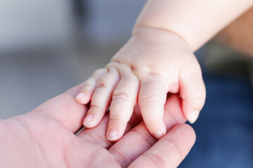 The mother is holding the hand of the child. Mother's and child hands. Family concept