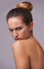 Keeping an eye on things. An attractive young woman against a purple background.