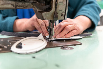 Leather patterns are sewn together by skilled hands to produce the product in greater quantity
