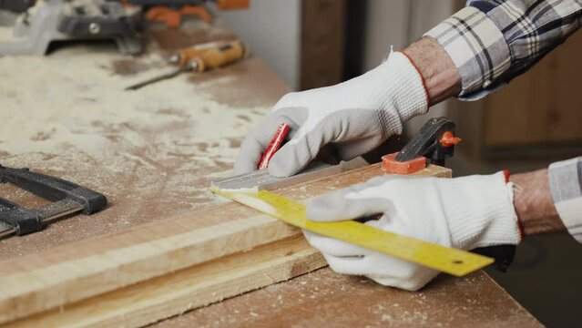Woodwork and furniture making concept. Carpenter in the workshop marks out the details of the furniture cabinet using a setsquare close up view. High quality 4k footage