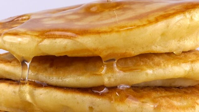 Pancakes with honey on a white background.