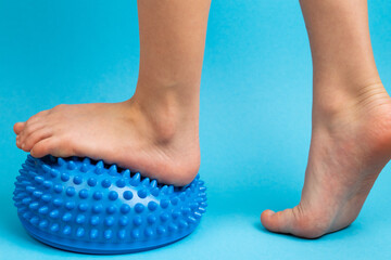 children's feet with a blue balancer on a light blue background, treatment and prevention of flat...