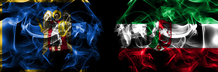 Kyiv, Kiev vs Germany, North Rhine Westphalia, state flag. Smoke flags placed side by side isolated on black background.