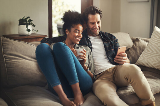Lock the door, leave the world outside. Shot of a happy young couple using a digital tablet while relaxing on a couch in their living room at home.