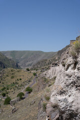 monastery in the mountains of georgia where there are caves and passages along the mountain, above them there is a blue sky.