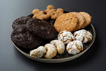 homemade chocolate oatmeal cookies sprinkled with sugar on a black background in a black plate