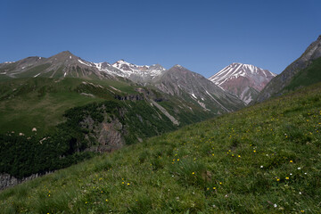 Fototapeta premium the Kazbegi mountain ranges in Georgia are green and have a clear sky above them.