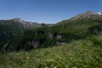 Fototapeta premium the Kazbegi mountain ranges in Georgia are green and have a clear sky above them.
