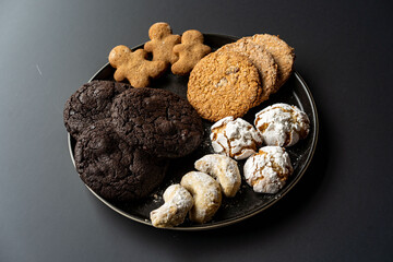homemade chocolate oatmeal cookies sprinkled with sugar on a black background in a black plate