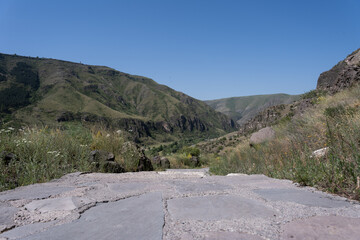 Georgia's rocky mountains with green bushes along the edges and a small road between them