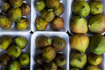 yellow-green small fruits are put up in bright white boxes on the market