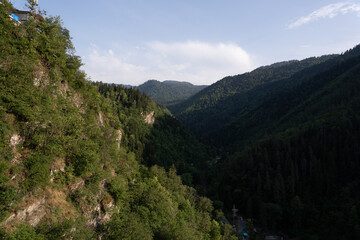 Obraz premium Mountain view of Georgia in the village of Borjomi with beautiful blue skies and dark green tree-covered mountains