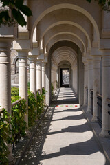 the corridor of the castle park with beautiful columns between which the bright sun shines