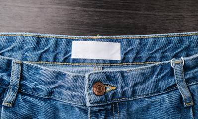 Blank clothing label on denim jeans texture. Label with empty space for text