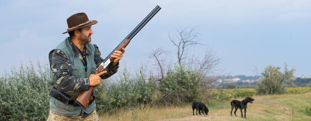 Hunter man in camouflage with a gun during the hunt in search of wild birds or game. Autumn hunting...