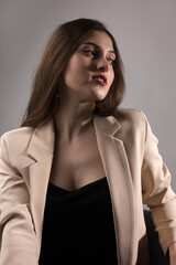 Portrait of a young brunette with long hair in the studio. Dramatic photo in dark colors.