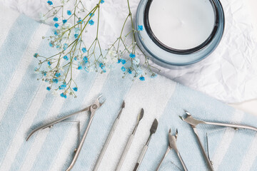 Manicure tools are laid out on a white-blue striped towel, studio photo