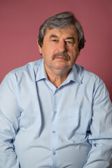 Portrait of elderly man on pink color background