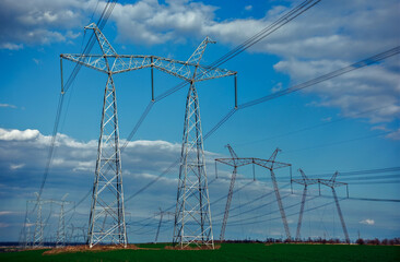 Fototapeta na wymiar high-voltage power lines at sunset. greeb field.