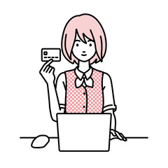 デスクで座ってPCを使いながらクレジットカードを手に持っている事務員制服の女性