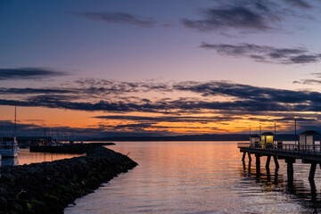 Obraz premium A fishing pier and marina at sunset, with clouds in the sky