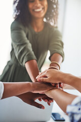 Unity in a business team is very important. Cropped shot of a group of unrecognizable businesswomen piling their hands on top of each other in the office.