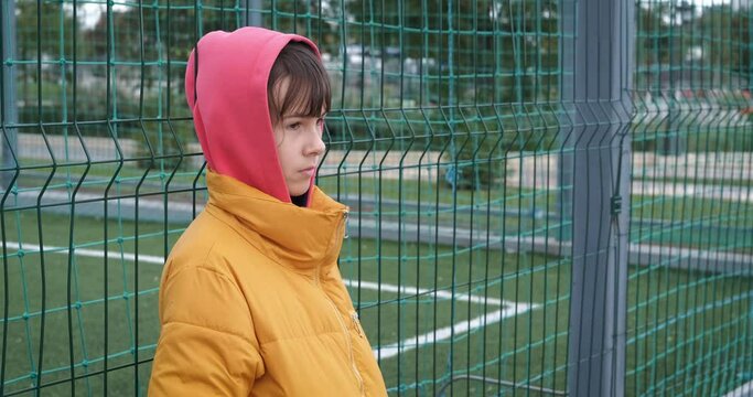 Girl by showground. A teenage girl with stressed mood look at the empty playground outdoor.