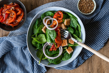 Healthy spinach salad with roasted red pepper.