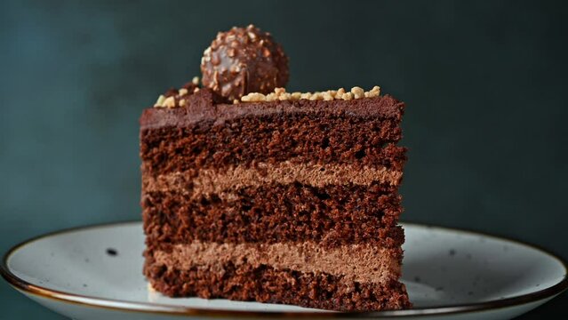 Piece of chocolate cake. Cake rotating. Chocolate dessert. Coffee cake on white plate.