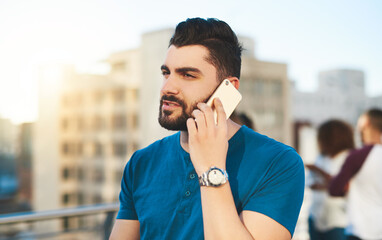 Talk to me. Cropped shot of a handsome young man making a phone call while standing outside.