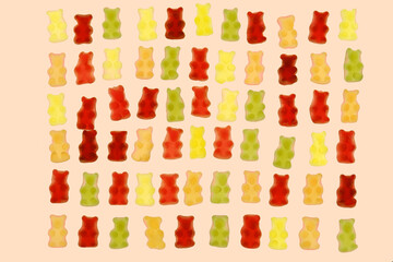 Naklejka premium Jelly bears candy isolated on a beige background.Jelly low-calorie sweets. Children's dessert.Jelly multicolored bears assorted set.Sweet pattern in yellow and red colors. Sweets and desserts.