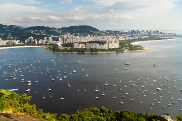 Naklejka premium Aerial image of Botafogo and Flamengo cove and beach with its buildings, boats and landscape. Immensity of the city of Rio de Janeiro, Brazil in the background
