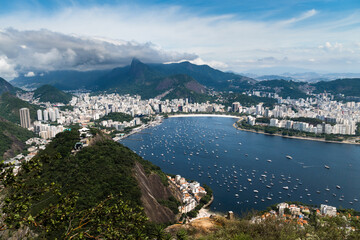 Aerial image of Botafogo and Flamengo cove and beach with its buildings, boats and landscape. Sugarloaf Mountain and the cable car. Immensity of the city of Rio de Janeiro, Brazil in the background