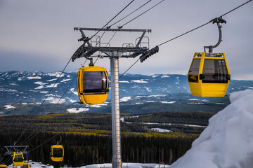 Gondola at ski resort. Chair lift with view of snowy mountains. Beautiful winter day at Big White Ski Resort. Kelowna. British Columbia. Canada. © thenikonpro