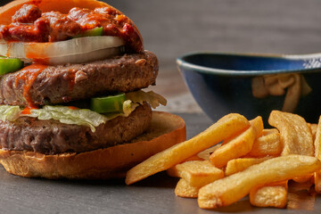 burger with fries onion chili with meat and jalapenos barbecue sauce dark style food