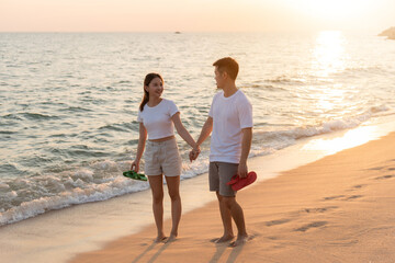 Vacation loving couple walking on beach together at sunset landscape, relaxing vacation travel...