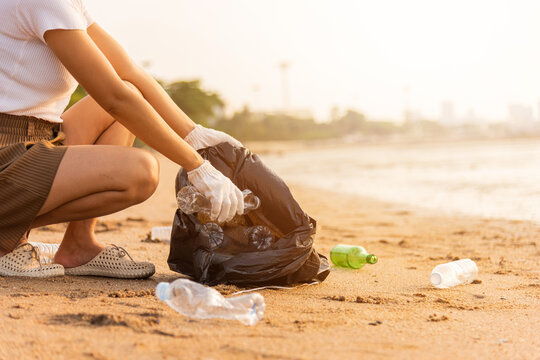 Volunteer Woman Picking Plastic Bottle Into Trash Plastic Bag Black For Cleaning The Beach, Female Clean Up Garbage, Ecology Concept And World Environment Day, Save Earth Concept