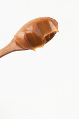 Dulce de leche in a wooden spoon.