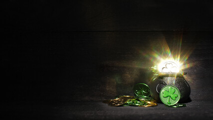 Festive St Patrick's Day background with a pot of sparkling gold and green coins.