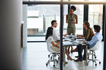 Bringing fresh ideas to the meeting. Shot of a group of businesspeople having a meeting in a...