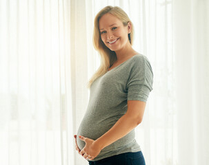 This is my last trimester. Shot of a beautiful woman holding on to her pregnant belly.