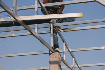 Construction worker with roof structure at construction site with nature light, Hard work It is...