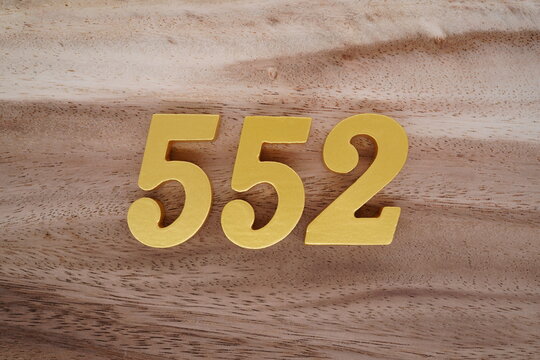 Golden Arabic numerals on a real brown and white wooden floor number 552