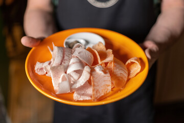 sliced frozen fish. raw frozen fish cut into shavings on a wooden background.