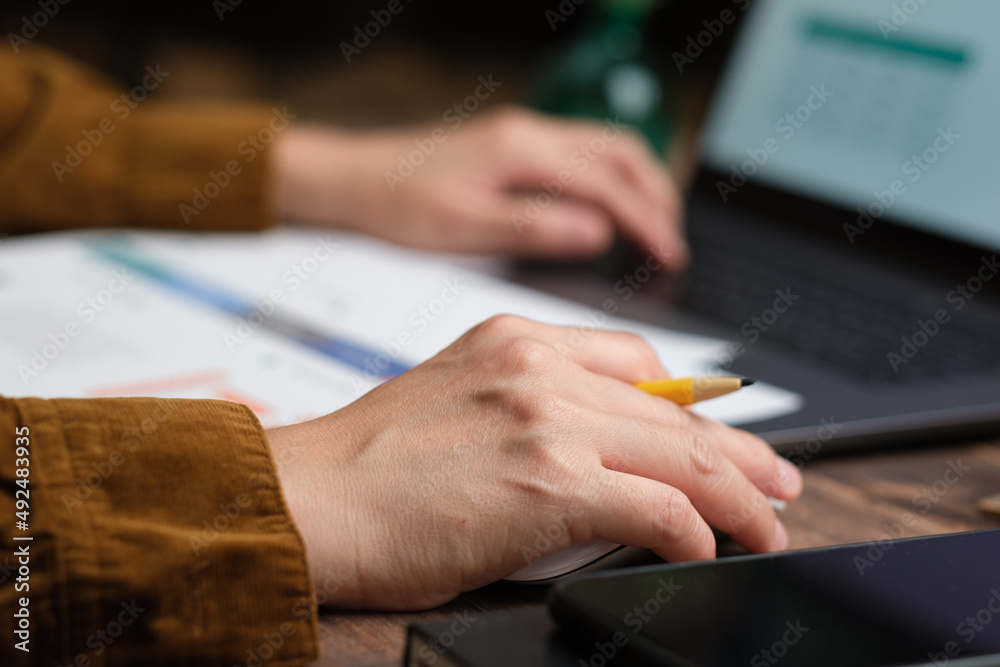 Poster close up hand using mouse and typing on laptop keyboard when woking at home