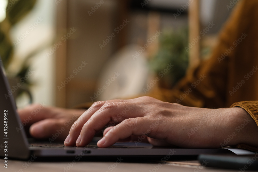 Poster close up hand typing on laptop keyboard when woking at home