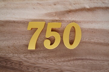 Golden Arabic numerals on a real brown and white wooden floor number 750